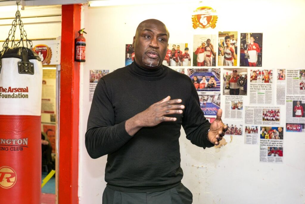 Derek speaking to a group in a boxing gym