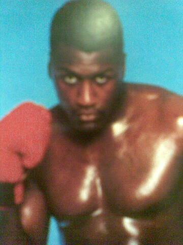 A young Derek Williams in a boxing stance, wearing red gloves
